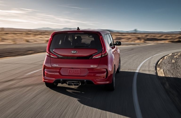 One red color 2021 Kia Soul is running on the road.